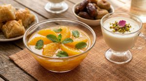 Salade d'oranges à la menthe et verrine lactée sur une table en bois.