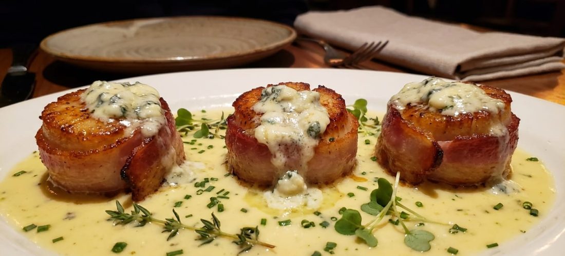 découvrez notre recette savoureuse de délice de coquilles saint-jacques au lard croustillant et fromage bleu fondant, un plat raffiné parfait pour toutes les occasions spéciales.